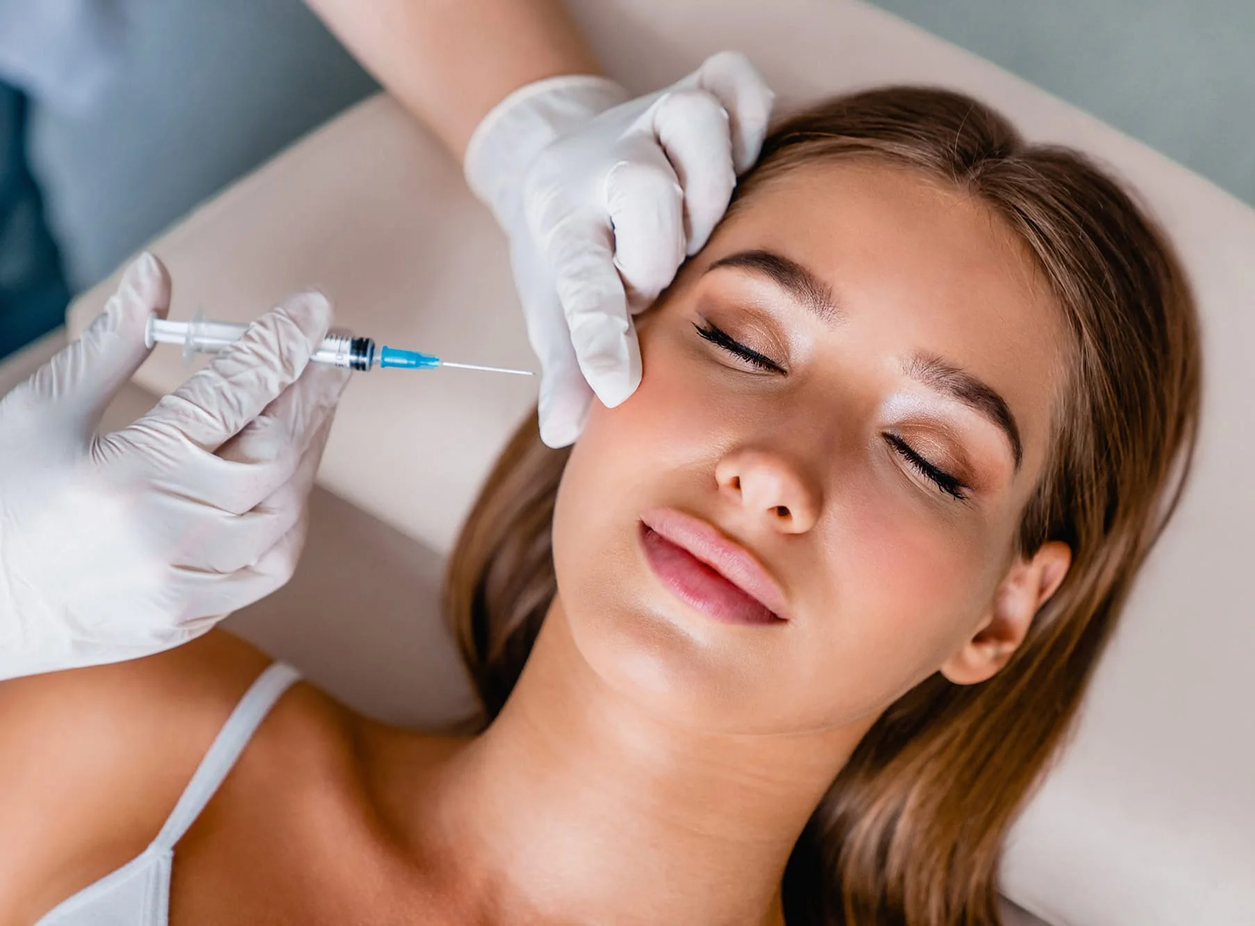 A practitioner prepares an injectable facial treatment.